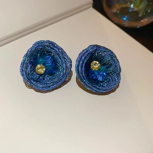 Macro shot of blue woven wire nest earrings featuring central crystal bead details