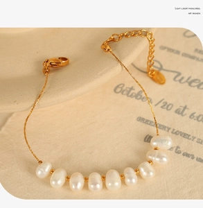 Gros plan du bracelet en perles plaqué or 18 carats avec fermoir mousqueton et pendentif