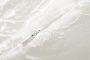 Detailed close-up of white invisible zipper on textured French vintage mini cami dress