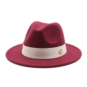 Detail of burgundy wool fedora featuring a beige grosgrain ribbon and gold metal buckle