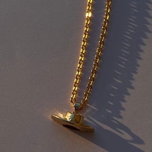 Dettaglio della collana con ciondolo a cappello da cowboy placcato in oro 18 carati