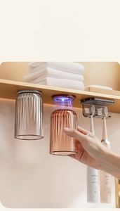 Detail of magnetic inverted toothbrush holder with translucent cups and storage shelf