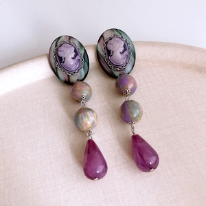 Macro detail of vintage cameo earrings with purple marble beads and teardrop pendants