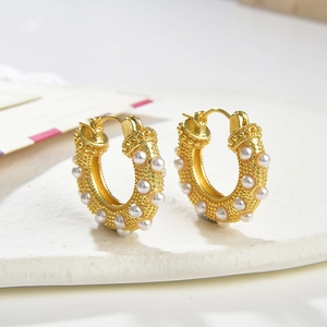 Elegant gold-plated hoop earrings with white pearls and detailed granulation textures