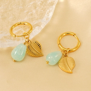 Boucles d'oreilles créoles dorées avec pendentif feuille et pierre verte sur satin