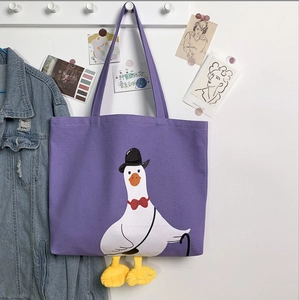 Detail of purple canvas tote bag featuring 3D plush goose feet and gentleman goose print