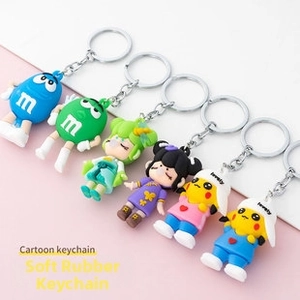 Macro detail of assorted cartoon soft rubber keychains with metal rings on pink background