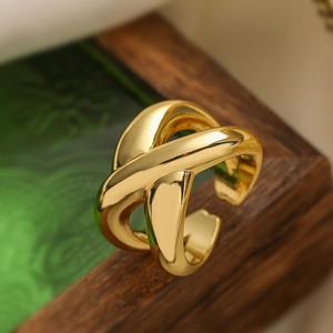 Irregular geometric gold metal cross open ring shown in a stylish close-up shot