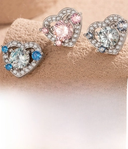 Detailed close-up of three heart-shaped stud earrings in silver titanium steel and zircon