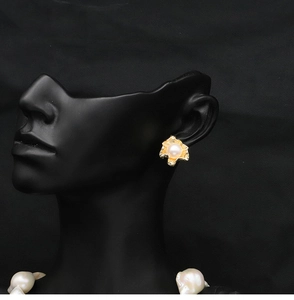 Detail of 18k gold-plated freshwater pearl earrings on mannequin with black background