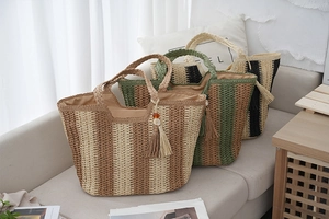 Straw tote bags with vertical stripes and tassel details in beige, green, and black