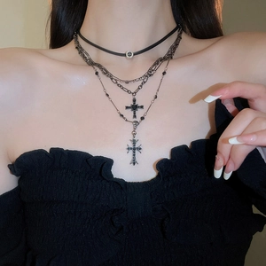 Dettaglio della collana a croce gotica a strati con choker in pelle nera e catene argento
