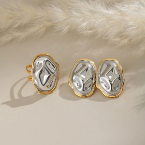 Vue macro de boucles d'oreilles et bague ovales martelées bicolores aux bords dorés