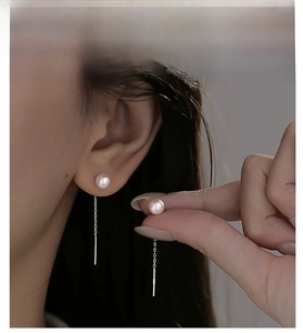Détail de fils d'oreilles en argent S925 avec perles blanches et chaîne fine