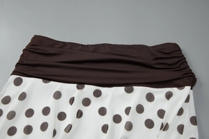 Détail de la taille haute plissée marron et de la jupe blanche à pois marron