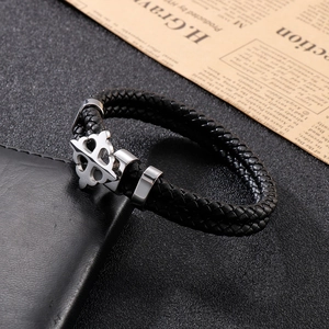 Close-up of men's black braided leather bracelet with a silver steel cross buckle on a wallet