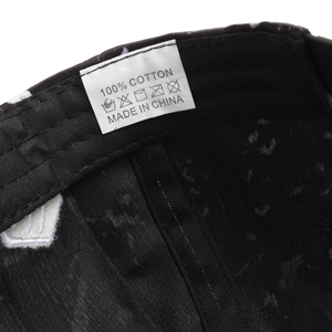 Detail of internal care label on a 100% cotton hip hop cap showing washing instructions