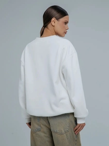 Πίσω όψη λευκού oversized φούτερ που δείχνει τη λεπτή υφή και τη χαλαρή γραμμή του