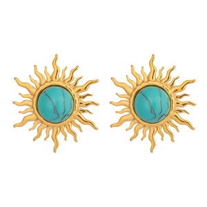 Close-up of vintage sun-shaped earrings with turquoise stones and gold metal finish