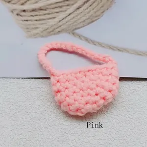 Dettaglio di una mini borsa rosa fatta a mano all'uncinetto con trama a maglia e manico