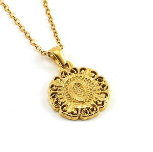 Detailed view of vintage gold round relief pendant necklace with ornate floral patterns
