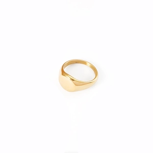 Macro view of a gold signet ring featuring a polished round flat surface for engraving
