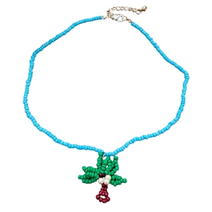 Close-up of tropical beaded necklace with handcrafted green coconut tree pendant