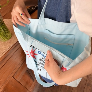 Detail view of large canvas tote bag interior showing spacious pocket and zipper