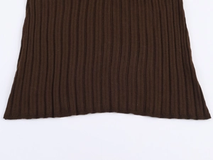 Detail of dark brown ribbed knit fabric hem showing stitching and soft texture