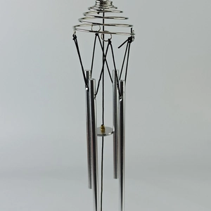 Close-up detail of silver stainless steel wind chime with tree of life spinning design