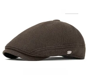 Detailed texture of brown wool blend knit fabric on newsboy cap with silver M logo