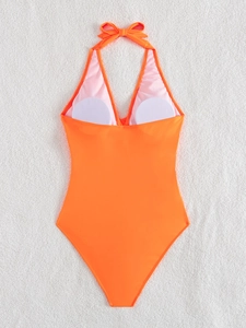 Detail of bright orange one-piece swimsuit with halter neck and deep V-neckline