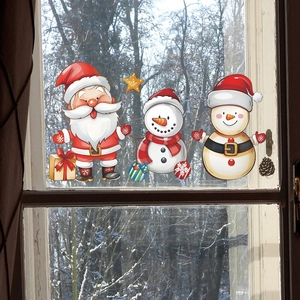 Detail of Christmas window clings featuring Santa and snowmen on glass with forest background