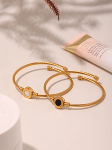 Detail of 18k gold plated spiral open bangles with black and white mother of pearl