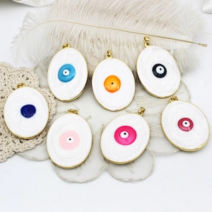 Assorted colorful evil eye charms with gold plating on white feather and lace texture