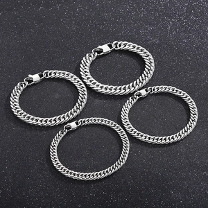 Set of four silver Cuban link bracelets with lobster clasps on a black background