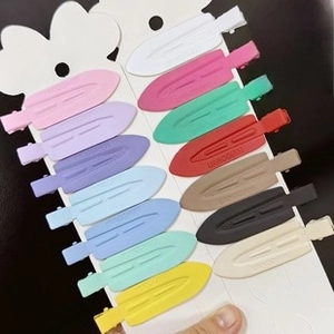 Macro detail of 14 colorful matte finish leaf hair clips on a white display card