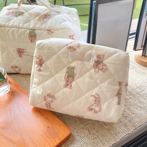 Detailed macro view of quilted cotton fabric texture with cartoon bear and rabbit prints