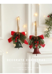 Close-up of vintage metal bells with burlap bows, pine cones, and red berries for Christmas