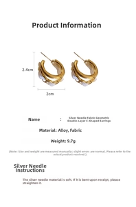 Detail view of double-layer C-shaped earrings with white fabric wrap and golden metal