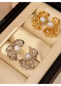 Close-up of gold and silver hollowed pearl earrings with zircon inlay in jewelry box
