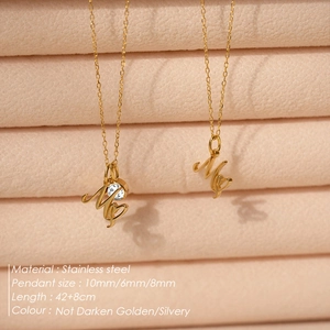 Detail of stainless steel initial M necklace with birthstone and heart pendant charms