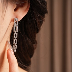 Gros plan de boucles d'oreilles pendantes argentées avec zircone sur un mannequin