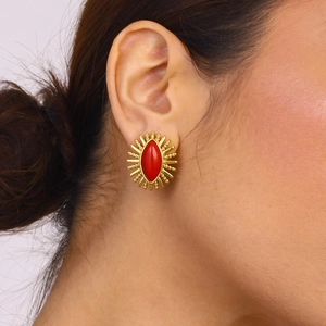 Detail of vintage gold earrings with marquise red stone on a model's earlobe