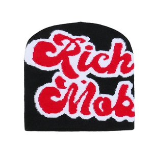 Detailed knit texture of a black beanie featuring red and white Rich & Mob lettering