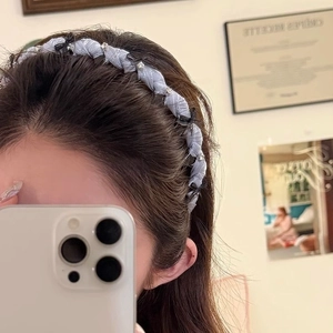 Lavender fabric headband with black bows and rhinestone accents worn by a woman