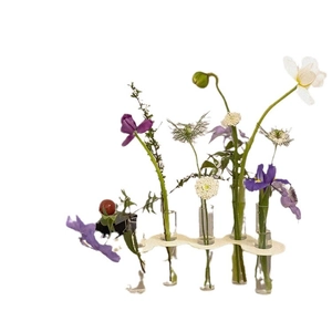 Modern acrylic test tube flower vase with white wavy base and colorful floral arrangement