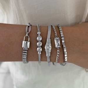 Five-piece silver stainless steel bracelet set with zircons and charms on a female wrist