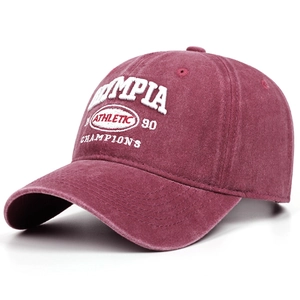 Detailed close-up of retro washed burgundy baseball cap with white athletic embroidery