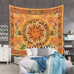 Detail of bohemian mandala tapestry featuring sun face and zodiac signs on a wall